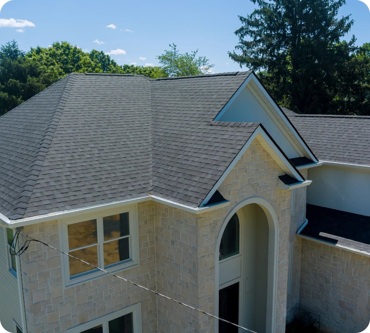 House with shingle roof and trees