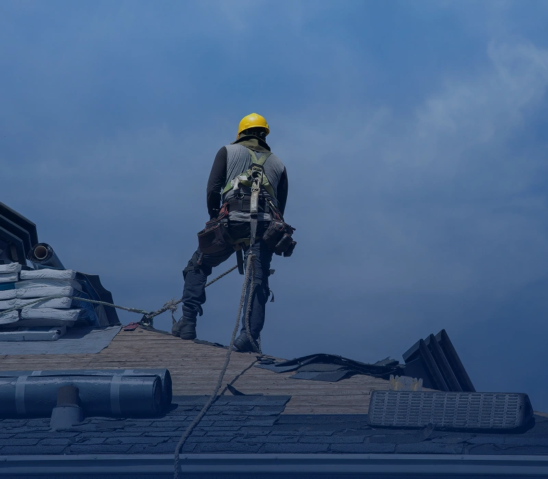 Roofer working on house rooftop