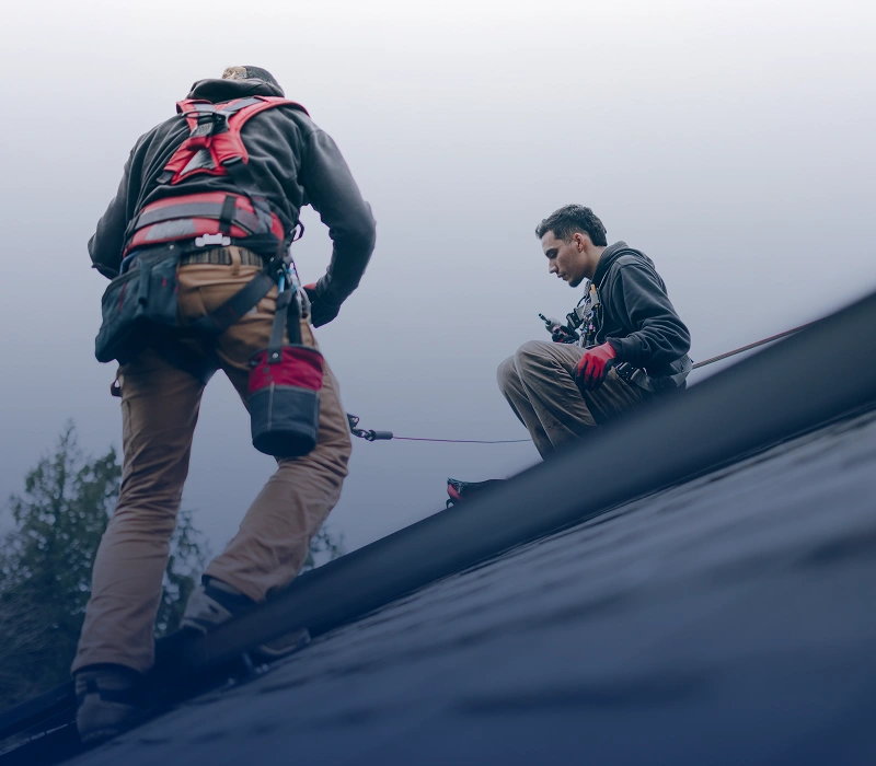 Roofers working on a sloped roof