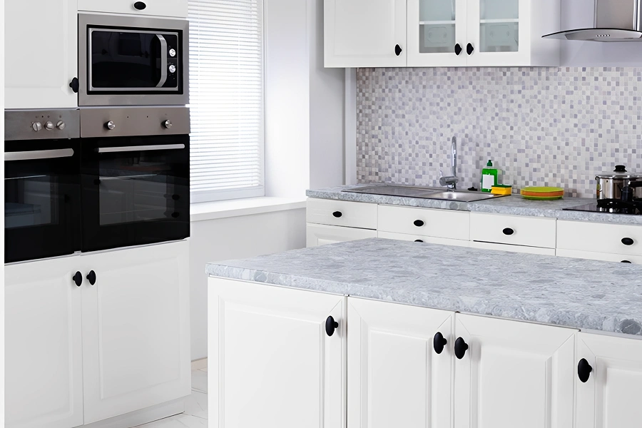 Modern kitchen with white cabinets and appliances.